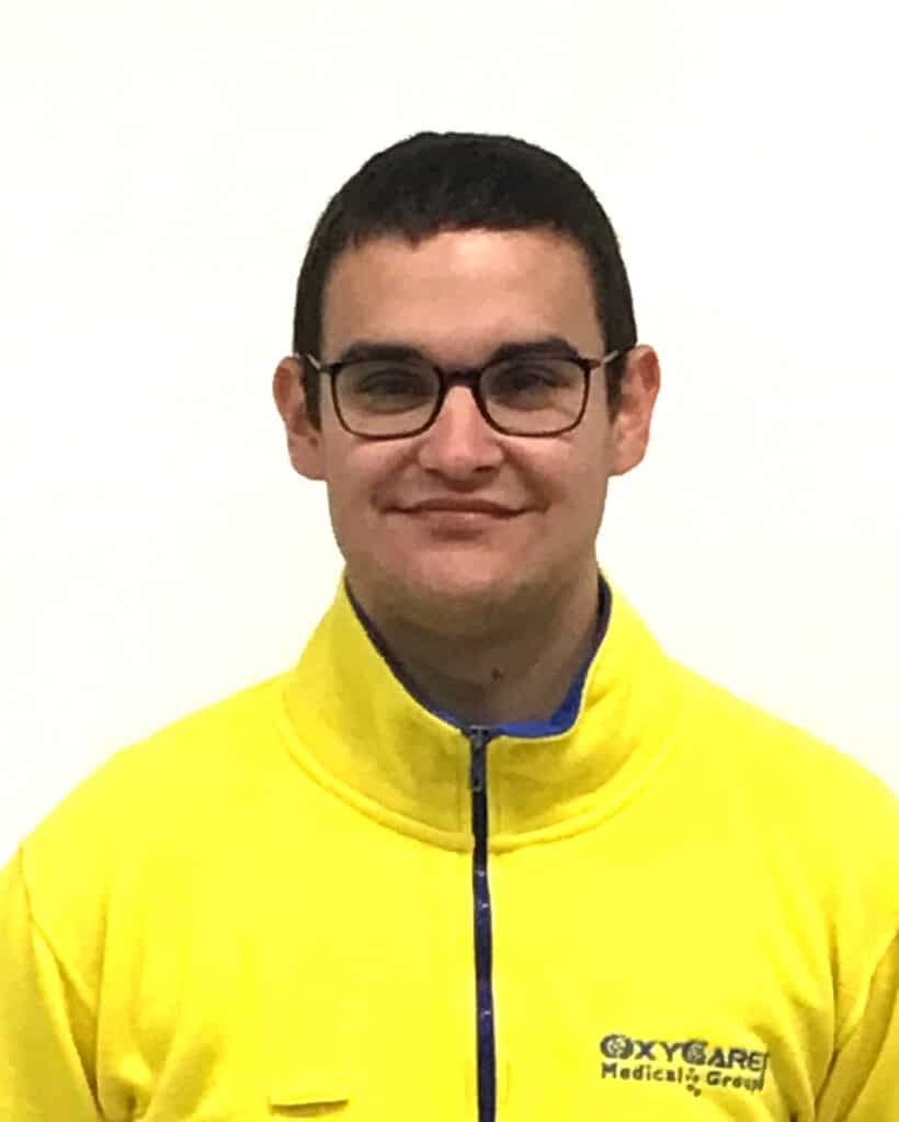 Foto von Maik Walzer, Mitarbeiter von OxyCare. Er trägt ein gelbes Hemd mit dem OxyCare Logo und schaut freundlich in die Kamera.